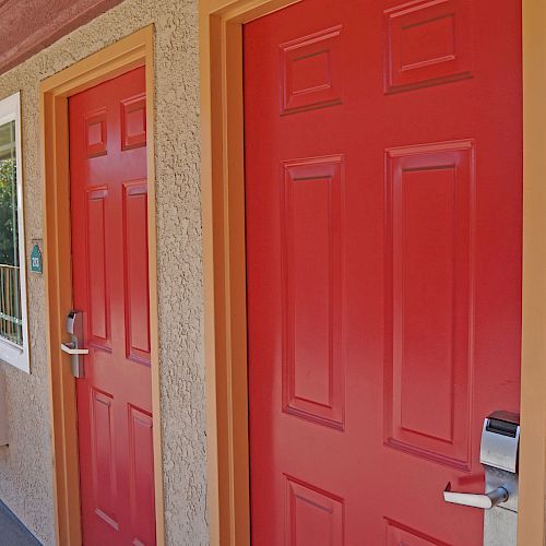 This image shows a series of red doors in a motel-like setting, with room 214 prominently visible. The doors have electronic locks and adjacent windows.